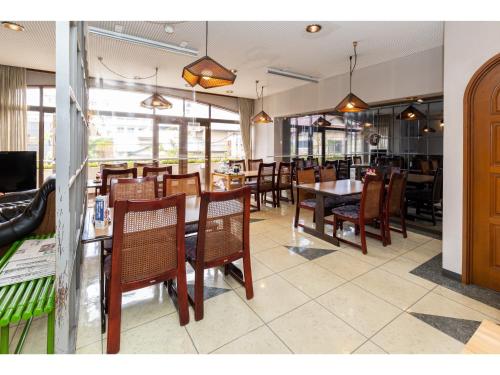 - une salle à manger avec des tables, des chaises et des fenêtres dans l'établissement Business Hotel Katsuya - Vacation STAY 62209v, à Wakayama