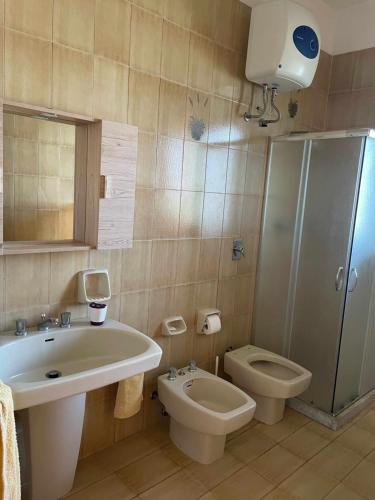 a bathroom with a sink and a toilet and a shower at Villa Mediterranean Sunset in Punta Braccetto