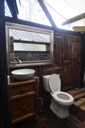 La salle de bains est pourvue d'un lavabo, de toilettes et d'un miroir. dans l'établissement Eco-Glamping Panorama, à Monterrey