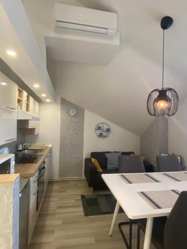 eine Küche und ein Wohnzimmer mit einem Tisch und einem Sofa in der Unterkunft Albert apartments Zagreb airport in Velika Gorica