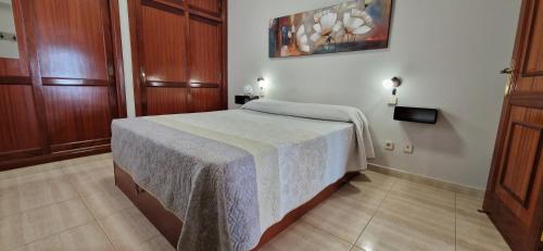 een slaapkamer met een bed met een deken erop bij Apartamento La Marisma in Puerto de Mogán