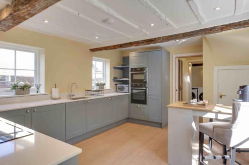 a large kitchen with blue cabinets and a counter at Josua Medieval Living Maldon in Maldon