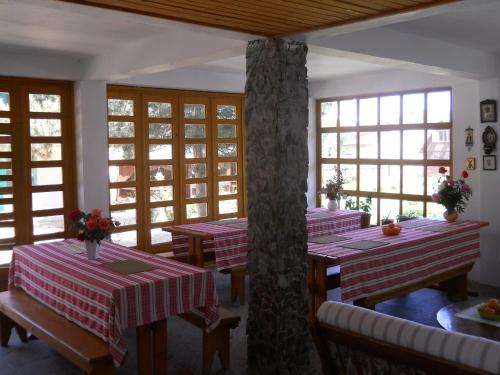a restaurant with red and white tables and windows at Pensiunea Sapte Pini in 2 Mai