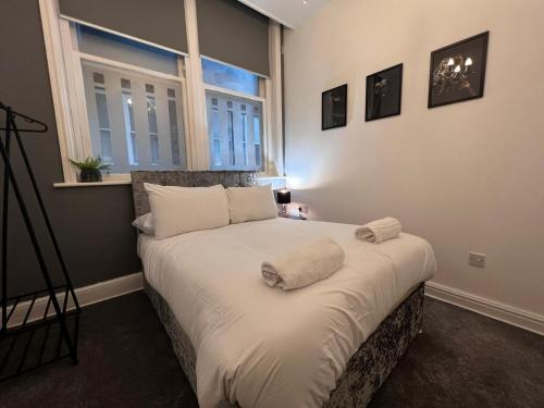 una camera da letto con un letto con lenzuola bianche e una finestra di Liverpool Centre 2 Bed Apartment a Liverpool