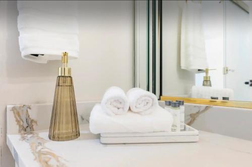 a bathroom with towels and a lamp on a counter at NEW! Spacious Art Deco Modern 5 BD/3BA Condo in Chicago