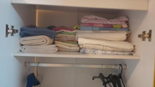 uma pilha de toalhas numa prateleira num armário em Brand New Extension Private Studio em Londres