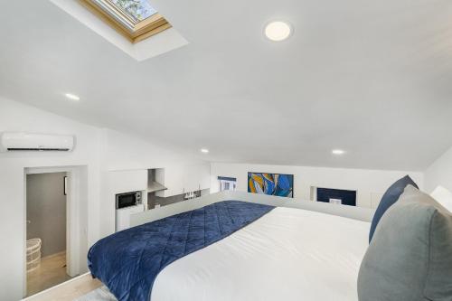 a bedroom with a large white bed with blue sheets at WHome Urban Escape: 1-BR w/mezzanine near Campo Ourique in Lisbon