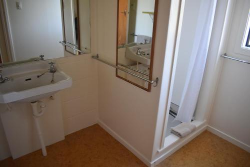 a bathroom with a sink and a mirror at Pukenui Lodge Motel in Pukenui