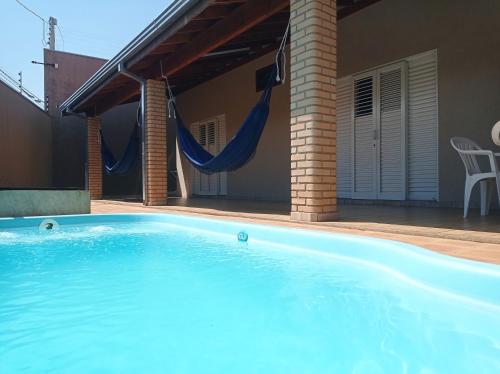 una piscina con amaca in una casa di Casa Temporada Belo Por do Sol a Olímpia