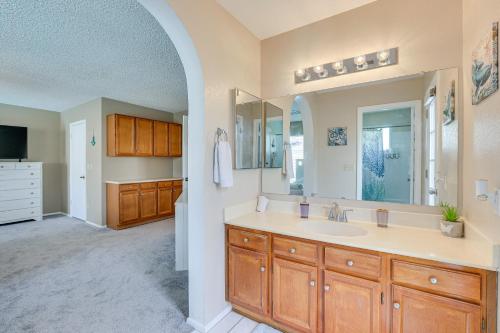 a bathroom with a sink and a large mirror at Family-Friendly Peoria Home with Pool and Fire Pit! in Peoria