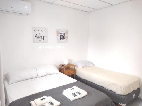 two beds in a room with white walls at ALFA SWEET APARTS in Formosa
