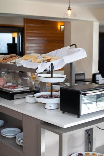 a buffet with several trays of food on a counter at Hotel Germania in Puerto Varas