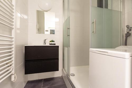 a white bathroom with a sink and a shower at T&K Apartments - 2 Room Apartment - Ground Floor in Düsseldorf