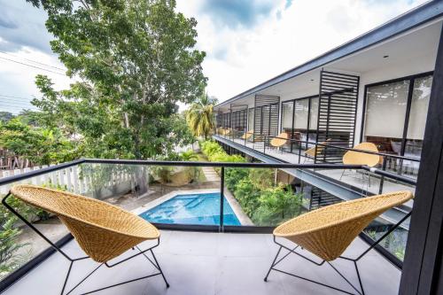 a balcony with chairs and a swimming pool at Deluxe Apartments Azure in Bacalar
