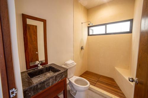 y baño con aseo y lavamanos. en Deluxe Apartmets Azure, en Bacalar