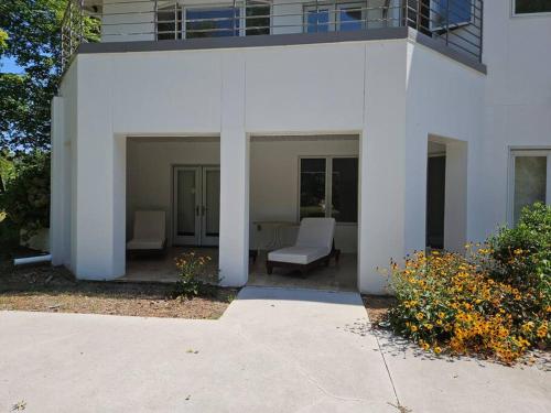 a white house with two chairs and a porch at Greensboro Lakefront House -K Idol House in McLeansville