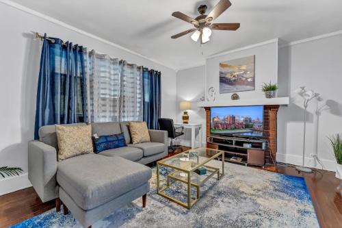 a living room with a couch and a tv at Renovated Main Floor Large 3 Bed House in Buffalo