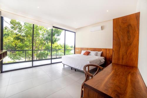 um quarto com uma cama e janelas grandes em Deluxe Apartmets Azure em Bacalar