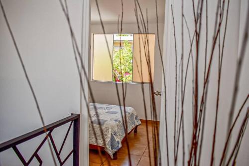 Cette chambre comprend un miroir, une chaise et une fenêtre. dans l'établissement Mountain Home, à Huaraz