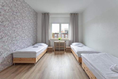 ein Zimmer mit zwei Betten und einem Fenster in der Unterkunft T&K Apartments - Apartments 20 Min to MESSE DUS in Krefeld