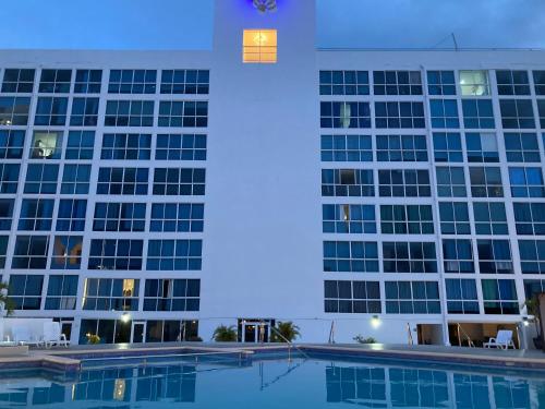 a large building with a pool in front of it at Tu Apartamento en Coronado in Chame