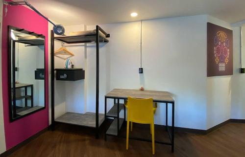 a dining room with a table and a yellow chair at Estancias VIVE MX cuauhtémoc in Mexico City