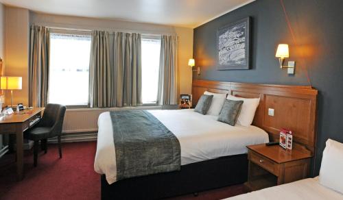 a hotel room with a bed and a desk at Brentwood Inn by Greene King Inns in Rotherham