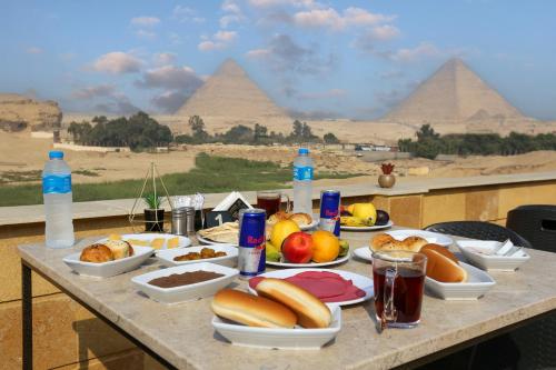 uma mesa com comida com as pirâmides em Pyramids Land Hotel em Cairo