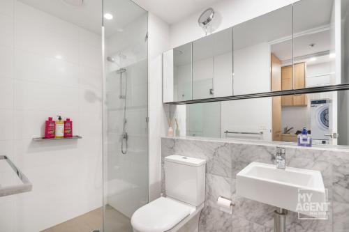 uma casa de banho branca com um WC e um lavatório em Experience Port Melbourne on Delightful Dow Street em Melbourne
