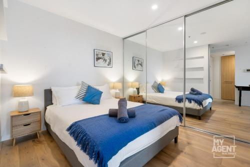 um quarto com 2 camas e um espelho em Experience Port Melbourne on Delightful Dow Street em Melbourne
