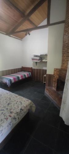 um quarto com duas camas e uma lareira em Fazenda Tapinuã em Silva Jardim