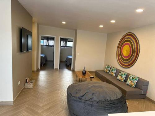 uma sala de estar com um sofá e uma televisão em Habitación 21 - Green Casitas em Ensenada