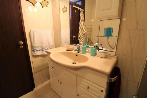 biała łazienka z umywalką i prysznicem w obiekcie Apartamento Figueira da Foz - Praia do Relógio w mieście Figueira da Foz