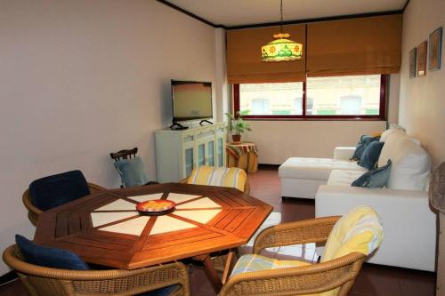 a living room with a wooden table and chairs at Apartamento Figueira da Foz - Praia do Relógio in Figueira da Foz