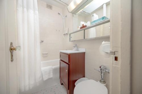a bathroom with a toilet and a sink and a shower at The Baroness Hotel in Seattle