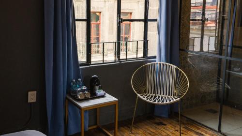 um quarto com uma cadeira e uma janela em Casa Pepe em Cidade do México