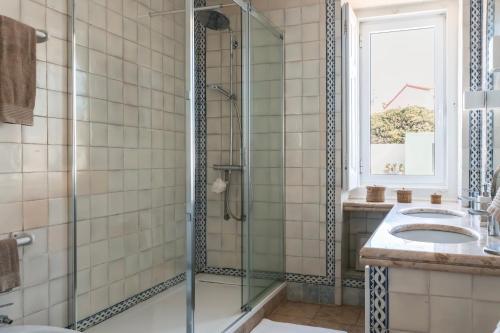 a bathroom with a glass shower and a sink at Villa Tamar - Azenhas do Mar in Azenhas do Mar