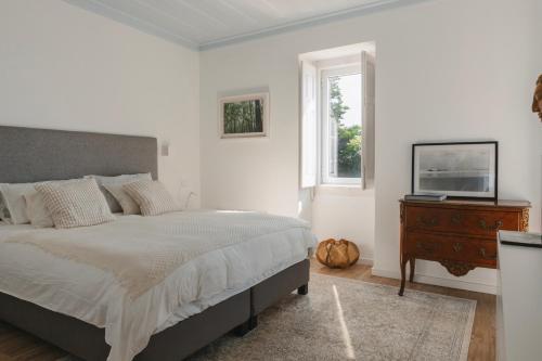 a bedroom with a bed and a television on a dresser at Villa Tamar - Azenhas do Mar in Azenhas do Mar