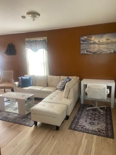 a living room with a white couch and a table at Queens chateau in Laurelton
