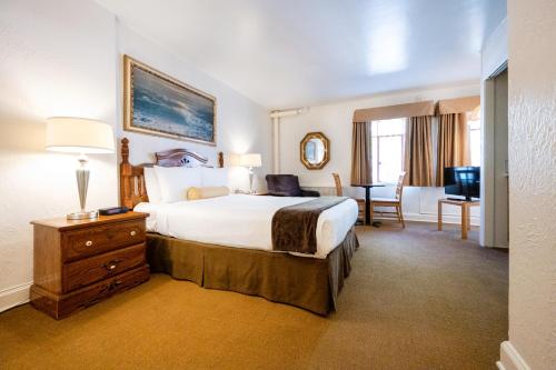 een hotelkamer met een groot bed en een bureau bij The Baroness Hotel in Seattle