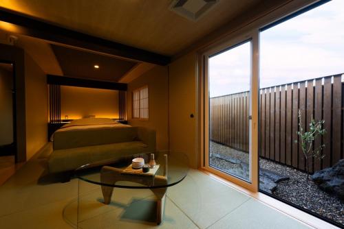 a bedroom with a bed and a glass table at HOTEL ZEN-Adult Only in Hirosaki