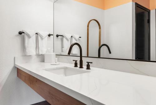 a bathroom with two sinks and two mirrors at Sandman Hotel in Santa Rosa