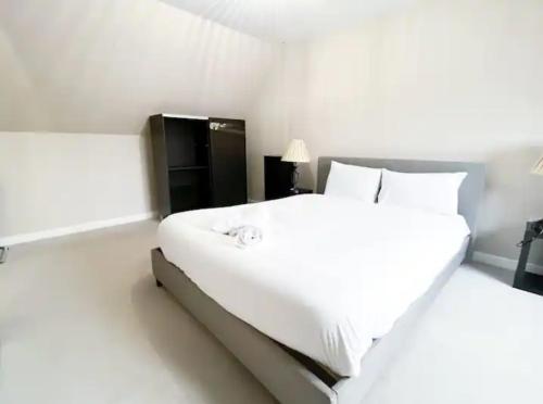 a white bedroom with a large bed with white sheets and pillows at Superb 3 Bed Home Away from Home in Glasgow, just off M8 with free parking in Steps