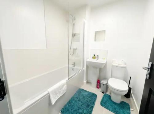 a white bathroom with a toilet and a shower at Superb 3 Bed Home Away from Home in Glasgow, just off M8 with free parking in Steps