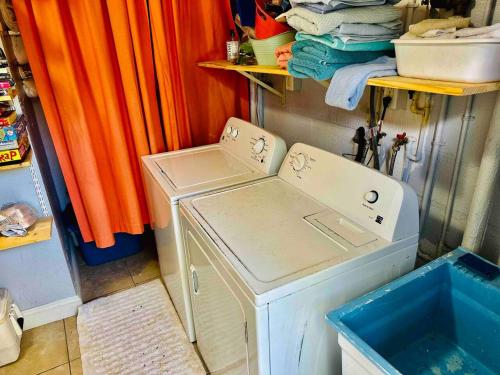 una lavadora en un lavadero con cortinas naranjas en Blue Water Beachside Villa 1 en Clearwater Beach