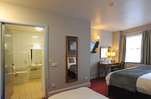 a hotel room with a bed and a bathroom at Brentwood Inn by Greene King Inns in Rotherham