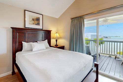 a bedroom with a large bed and a balcony at Reef House in Duck Key