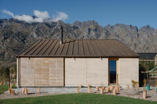 a large building with mountains in the background at The Earth House @ Jacks Point in Frankton Wharf