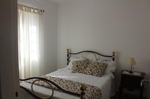 um quarto com uma cama e uma janela em Casa do Cabeço em Proença-a-Nova