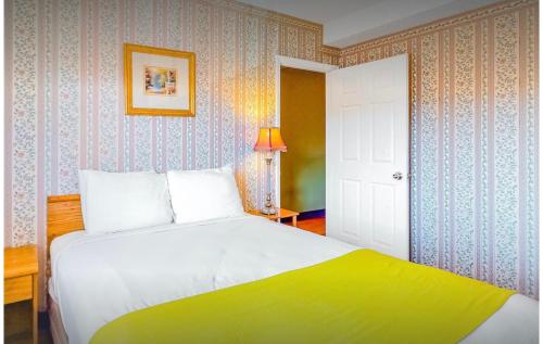 a bedroom with a white bed with a yellow blanket at RRP Condo in Pigeon Forge